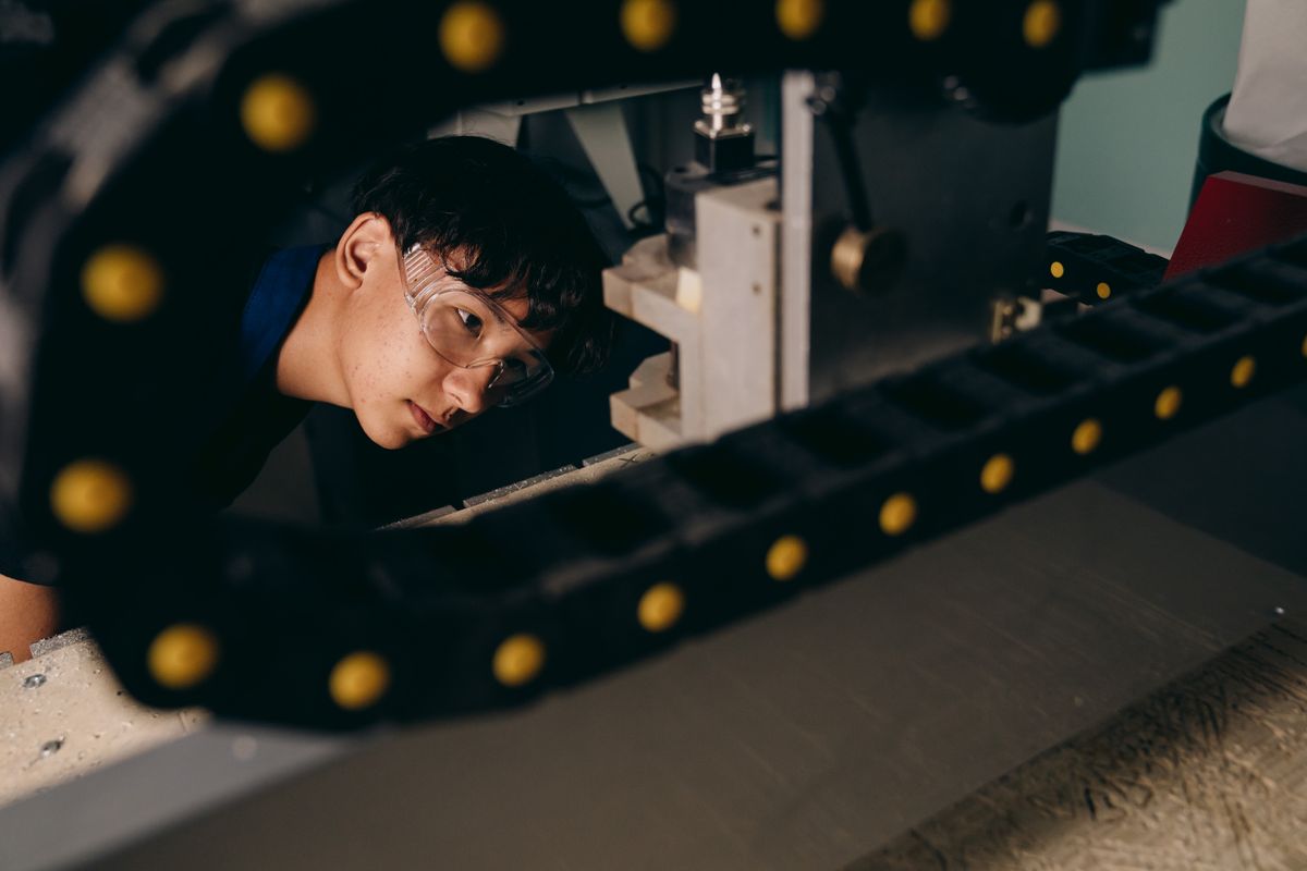 Engineer in safety goggles examining a component