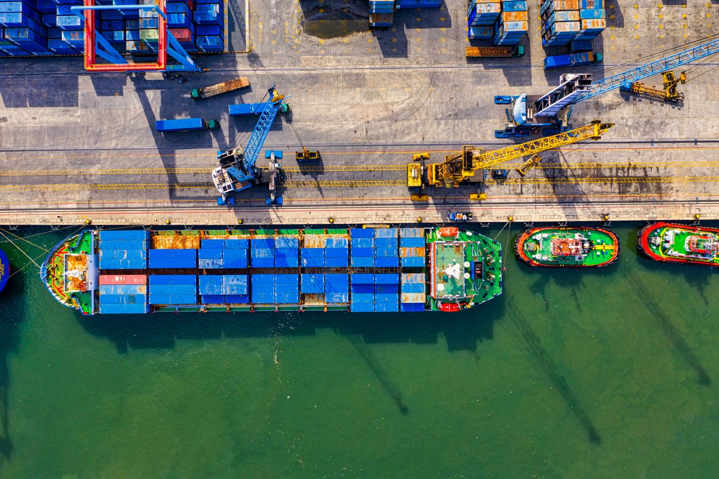 Aerial view of a container terminal with cranes and a moored vessel